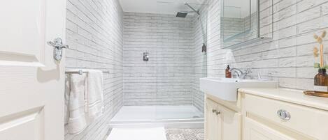 A modern bathroom with a shower, toilet, and vanity.