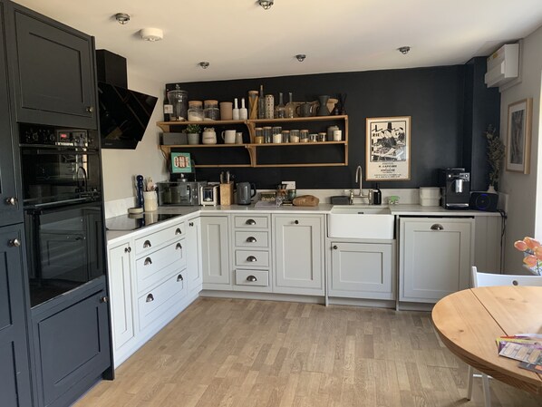 Enjoy cooking in this well-equipped kitchen with a sink, coffee machine, and ample utensils.