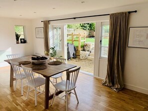 Enjoy meals in this dining room with a table for four, surrounded by framed pictures and a sliding door to the garden.