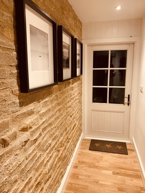 Stylish hallway with a door featuring a glass panel and framed artwork above.