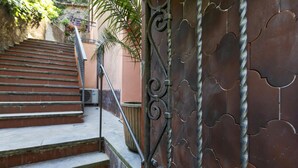 Eine Treppe führt zu einem Gebäude mit einem schmiedeeisernen Tor.