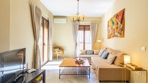 Una sala de estar moderna con un sofá, una mesa de centro, un televisor y una estantería.