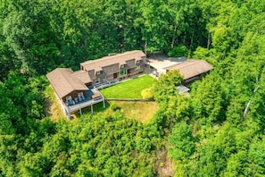 An aerial view of a large, multi-story building surrounded by dense forest. - Far Horizons: MtnView•HotTub•PoolTbl•KingSuites (Gatlinburg)