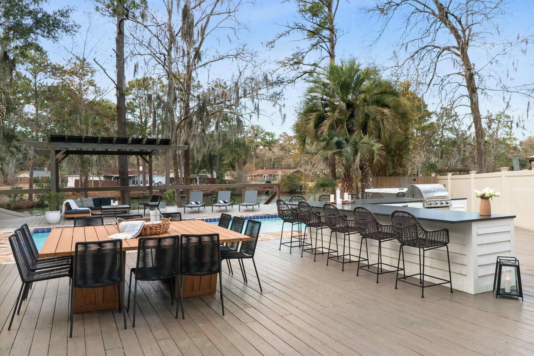 An outdoor patio with a pool, bar, and seating area.