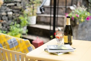 A table with a bottle of wine, glasses, and a book.
