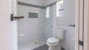 A modern bathroom with a glass-enclosed shower, a toilet, and a small window. - La Casita: Hot-tub & Firepit, 15 min to Fred! (Harper)