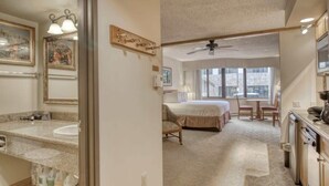 A bedroom with a bed, a desk, a chair, a window, and a ceiling fan. - Grand Lodge Studio | Walk to Crested Butte Lifts, Pool, Hot Tub, Dog-Friendly (Crested Butte)