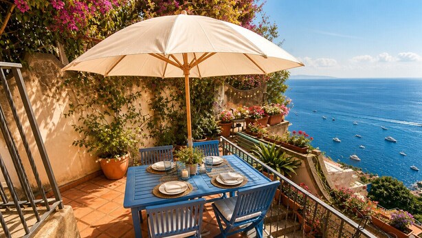 A terrace with a table set for two, a large umbrella, and a view of the sea. - AMORE RENTALS - Casa Laura with Sea View Terrace (Positano)