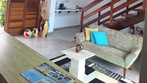 A modern living room with a sofa, a coffee table, and a staircase.