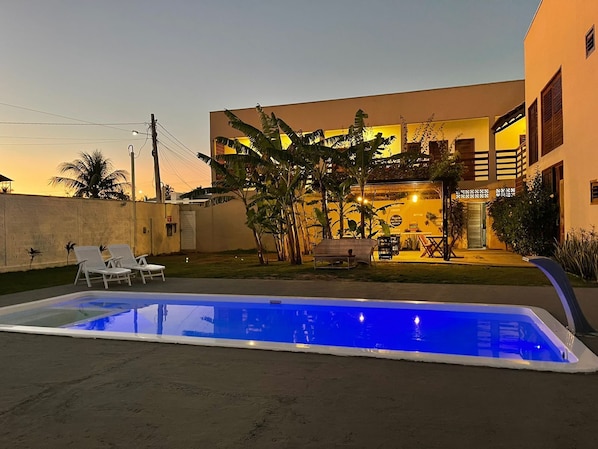 Uma casa moderna com piscina, móveis de exterior e vegetação exuberante.