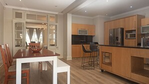 Een moderne keuken met houten kastjes, een roestvrijstalen koelkast en een zwart aanrecht.