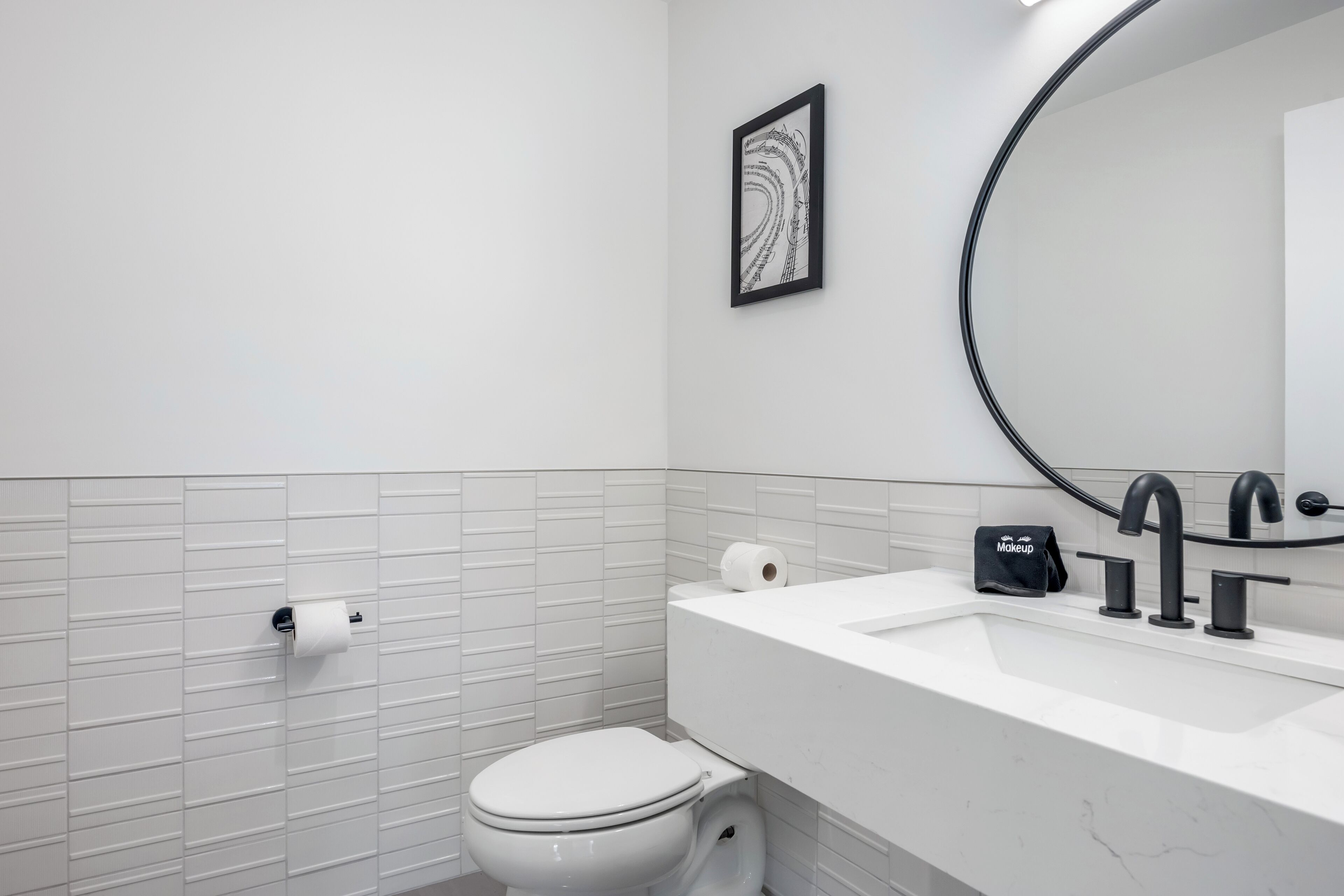 Un baño moderno con inodoro, lavabo y espejo.