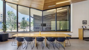 A conference room with a long table, six chairs, large windows, and a view of buildings and trees outside. - Motif on Nashville's Music Row (Nashville)