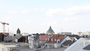 Ein Dach mit Solaranlagen, Satellitenschüsseln und einem Baukran.
