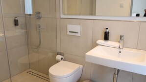 Ein modernes Badezimmer mit Dusche, Toilette und Waschbecken.
