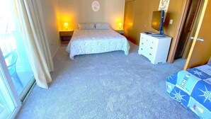 Quarto com cama, abajures, cômoda, espelho e porta.
