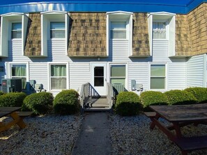 A two-story building with a central entrance, a covered porch, and a gravel driveway. - Gullway Townhouse 2823 3 Bedroom Townhouse by RedAwning (Ocean City)