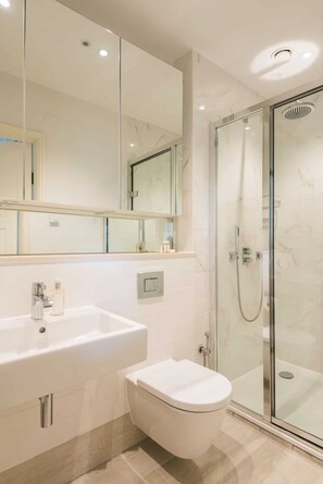 A modern bathroom with a glass-enclosed shower, a large white sink, and a toilet. - The Lofthouse -  a luxury waterside apartment (Salcombe)