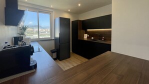 Eine moderne Küche mit integriertem Kühlschrank, einer Kaffeemaschine und einem Spülbecken.