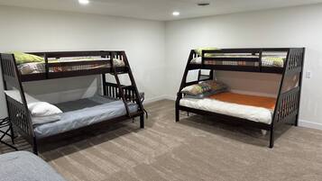 Deux lits superposés dans une chambre dont le sol est recouvert de moquette et les murs sont peints en blanc.