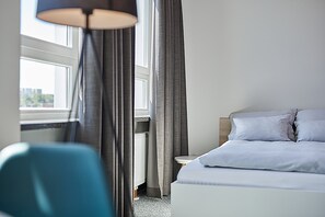 Ropa de cama hipoalergénica y caja de seguridad en la habitación 