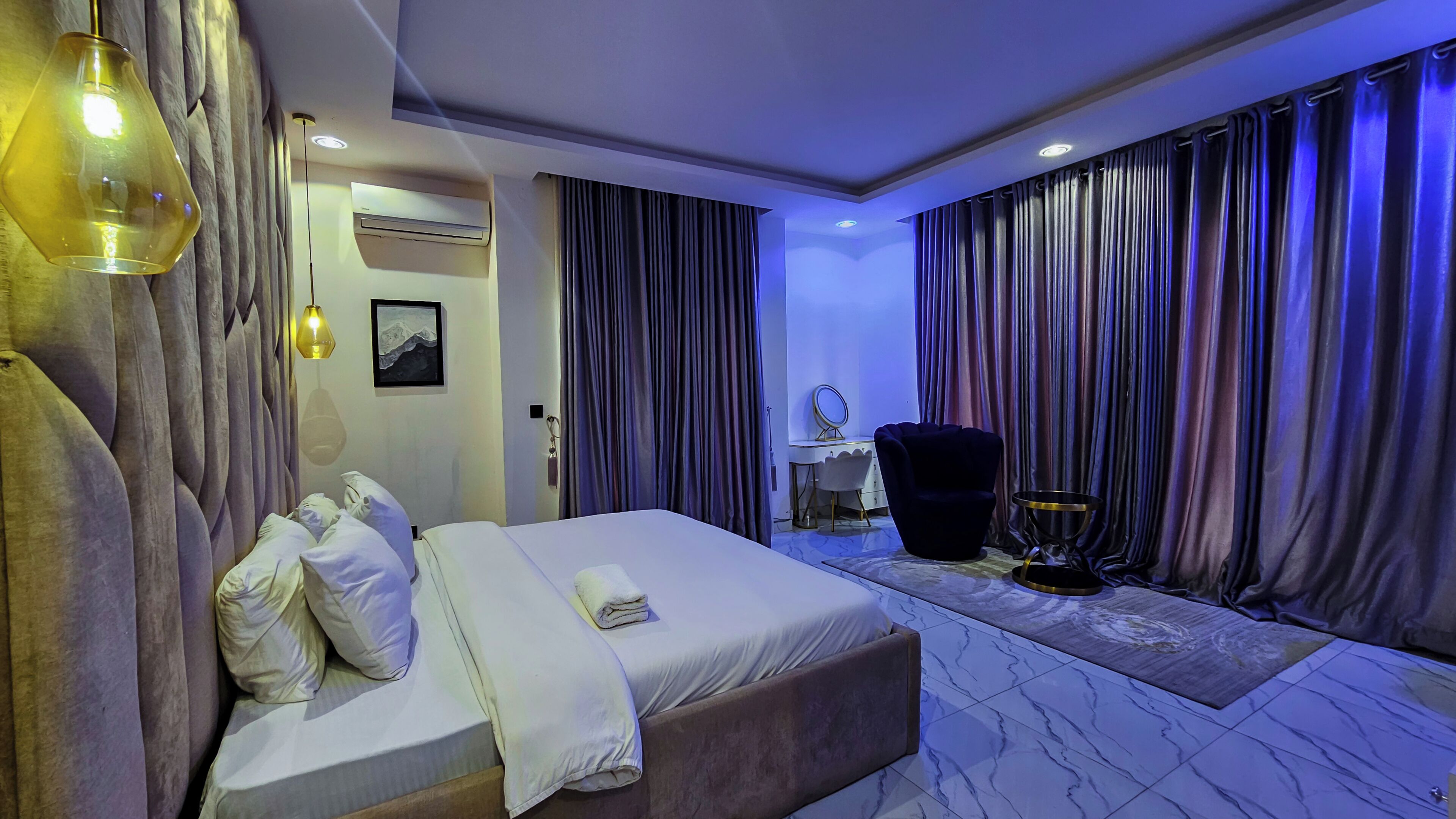Una habitación de hotel con cama, escritorio, silla y tocador con espejo.