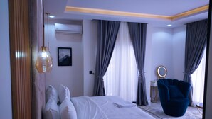 Une chambre à coucher moderne avec un lit, une chaise bleue et un miroir rond.
