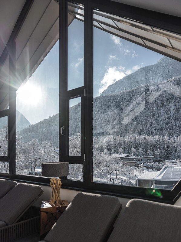 A room with a large window overlooking a snowy mountain landscape. - MYALPS Tirol (Oetz)