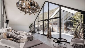 Et moderne interiør med et stort glasvindue, en markant loftlampe og behagelige siddepladser.