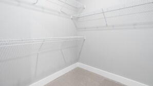 A corner closet with white metal shelving units and a beige carpet. - Lavish Apartment over Target in Downtown Auburn - 205 (Auburn)