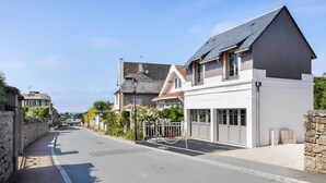 En bostadsgata med hus, en klar himmel och en trottoar.