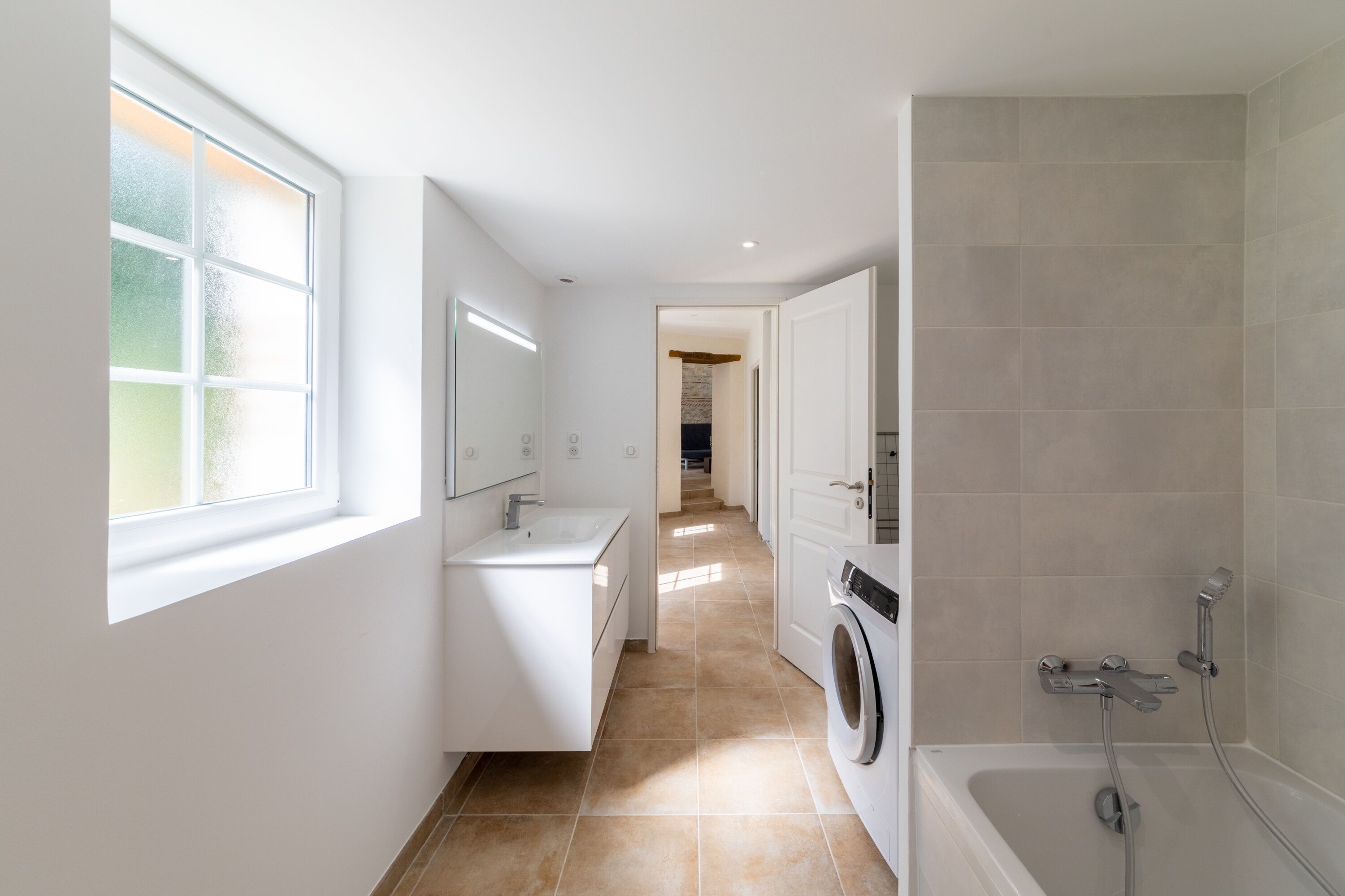 Une salle de bain moderne avec un lavabo, un miroir et une douche.
