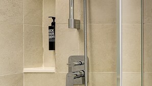 Een moderne douche met een handdouche en een flexibele slang.