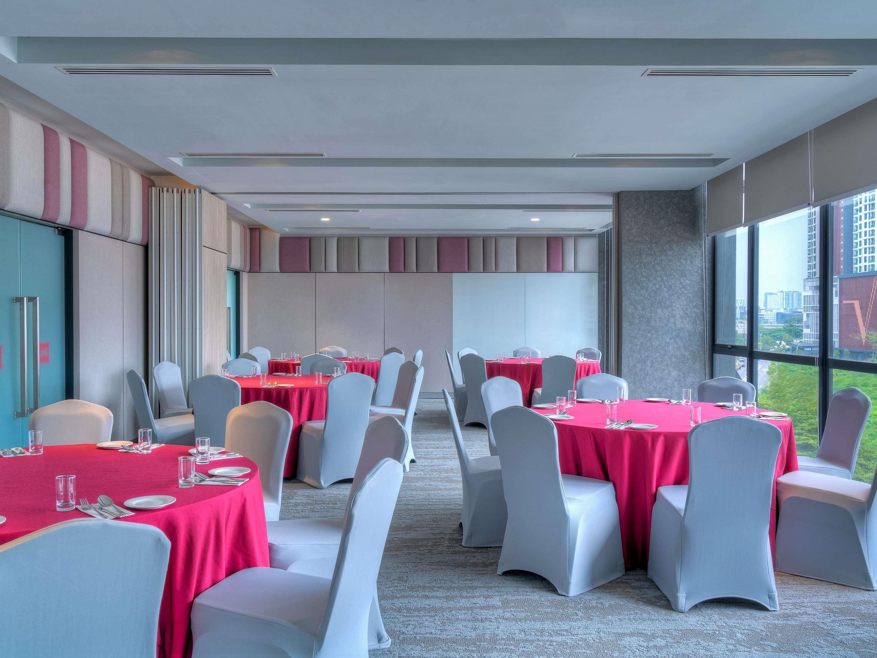 A conference room with tables set for meetings, large windows with a city view, and a modern interior design.