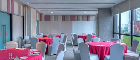 A conference room with tables set for meetings, large windows with a city view, and a modern interior design.