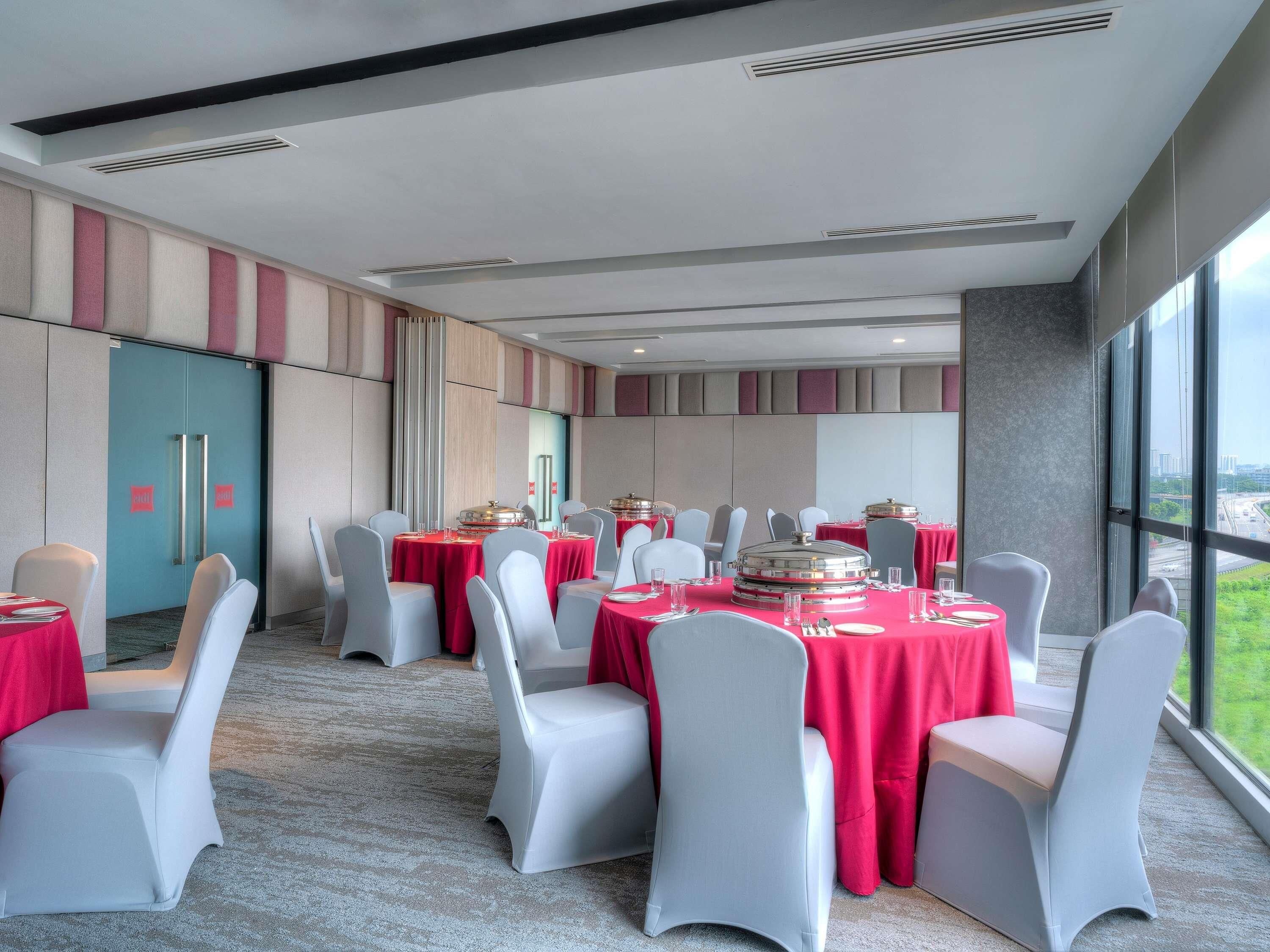A conference room with tables set for a meeting, large windows, and a view of the cityscape.