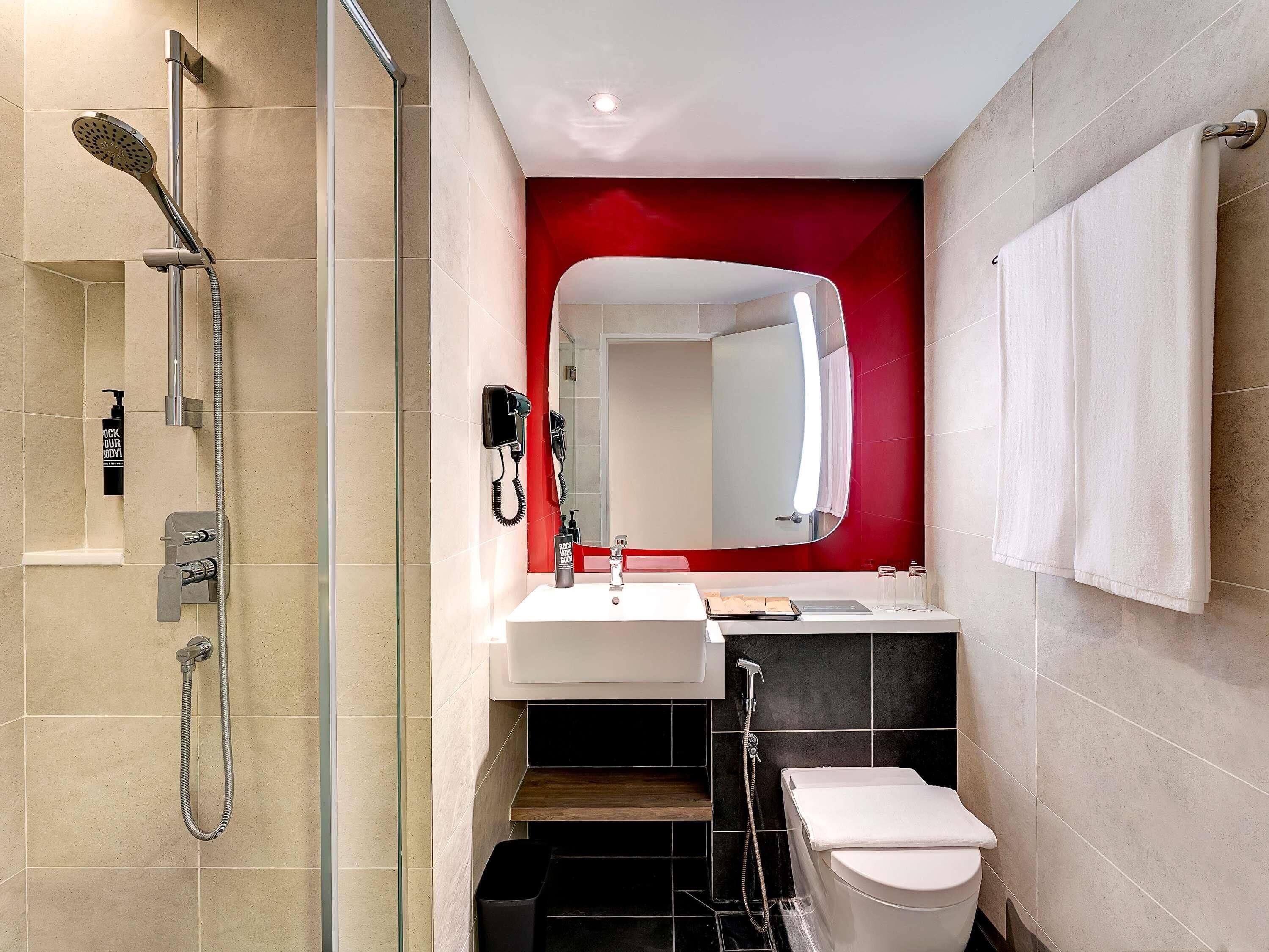 Un baño moderno con ducha, inodoro y lavamanos.