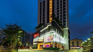 Een modern hotel met een opvallend ‘ibis’ bord, grote ramen en een goed verlichte ingang.