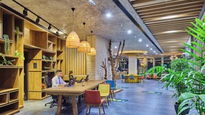 A modern office space with a long table, multiple chairs, and shelves with plants. - Ibis Istanbul Airport (Arnavutköy)