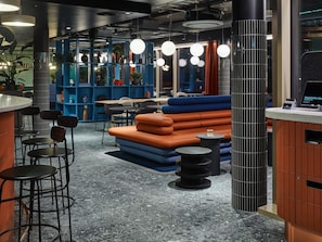 A modern interior with seating areas, tables, and a registration counter.