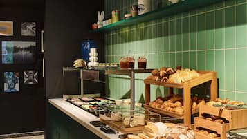 Ein Buffet mit verschiedenen Speisen, eine Auswahl dekorativer Gläser und eine Wand mit gerahmten Bildern.