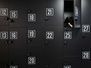 A row of black lockers with white numbers, each with a keyhole. - TRIBE Baden-Baden (Baden-Baden)