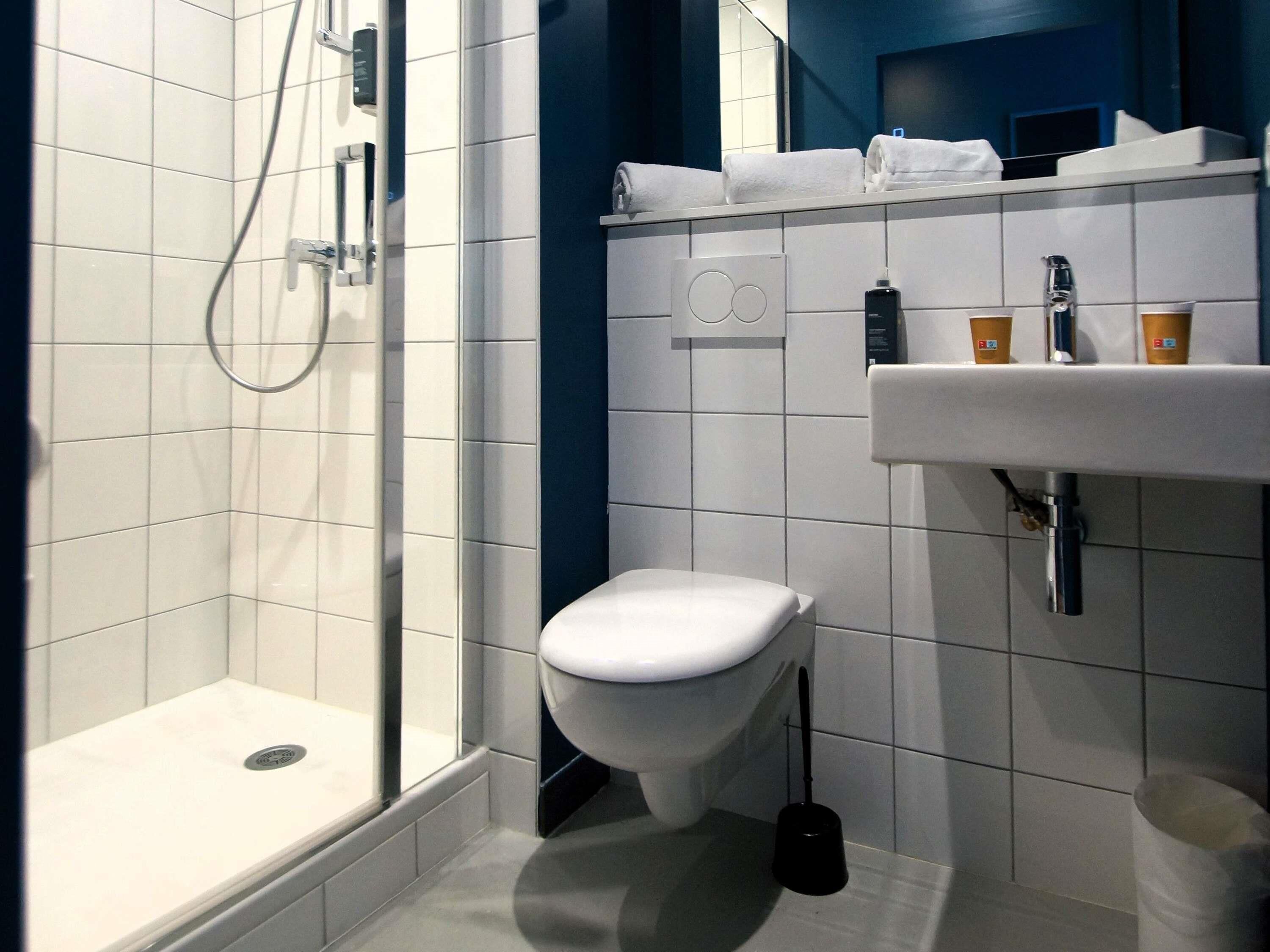 Un baño moderno con ducha, inodoro y lavabo.