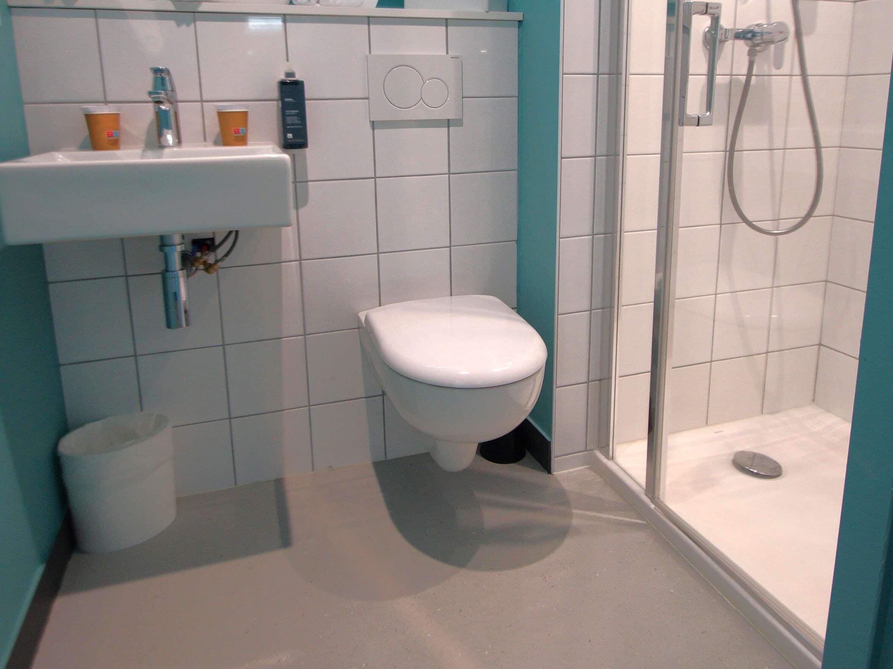 A bathroom with a toilet, sink, and shower.
