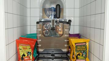 Una macchina da caffè con serbatoio trasparente, display digitale e vaschetta raccogligocce.