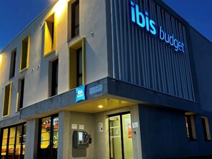 A building with the signage 'ibis budget' indicating a budget hotel. - Ibis Budget Loudéac Vélodrome (Ouverture Juillet 2023) (Loudeac)
