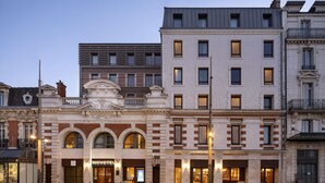 A hotel with a classic facade, featuring arched windows and a central entrance.