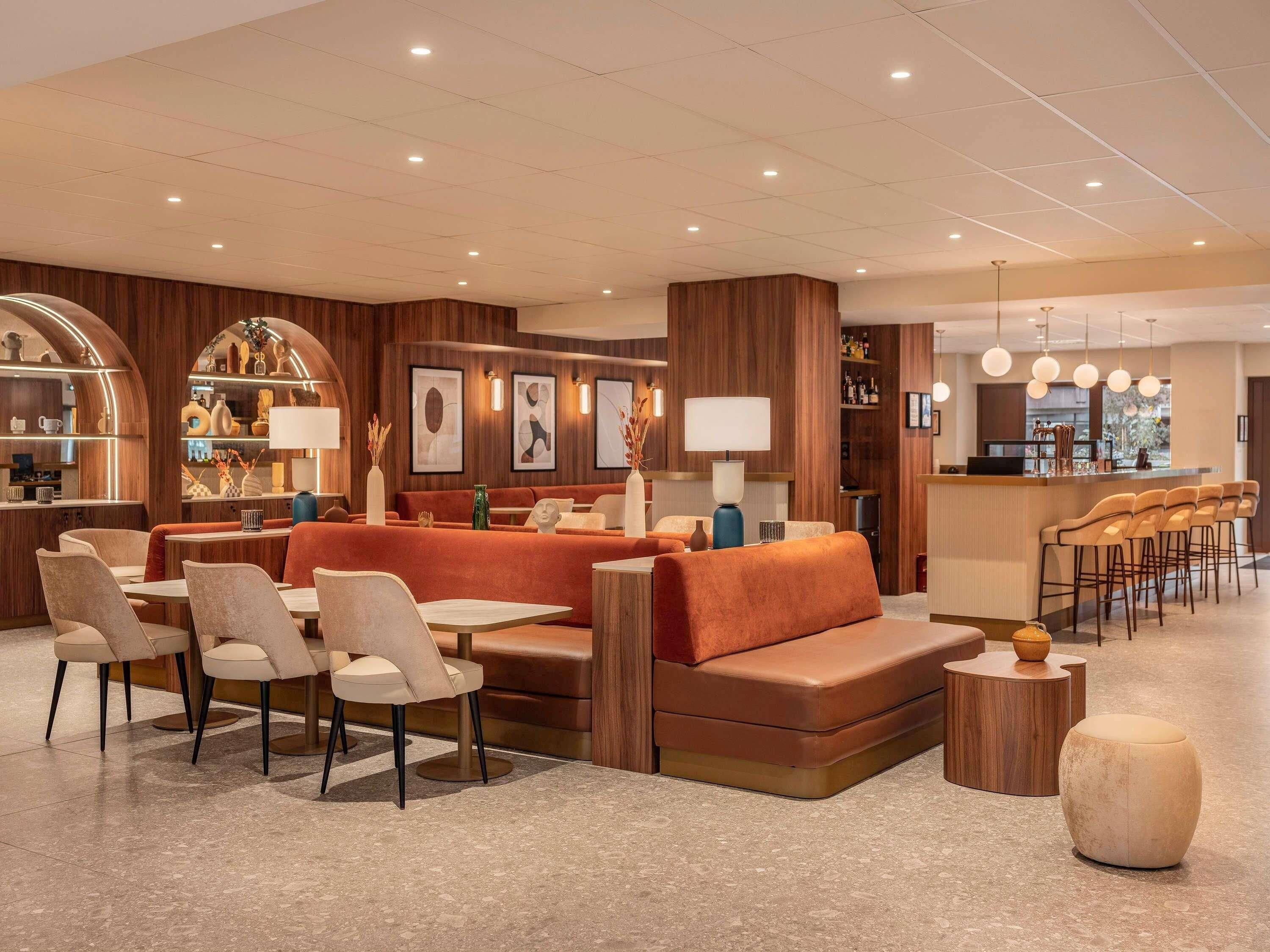A modern interior with a bar area, seating, and a view of the outdoors.