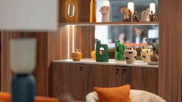 A modern interior with wooden paneling, a white countertop displaying various ceramic vases, and a window with a view of the outside.