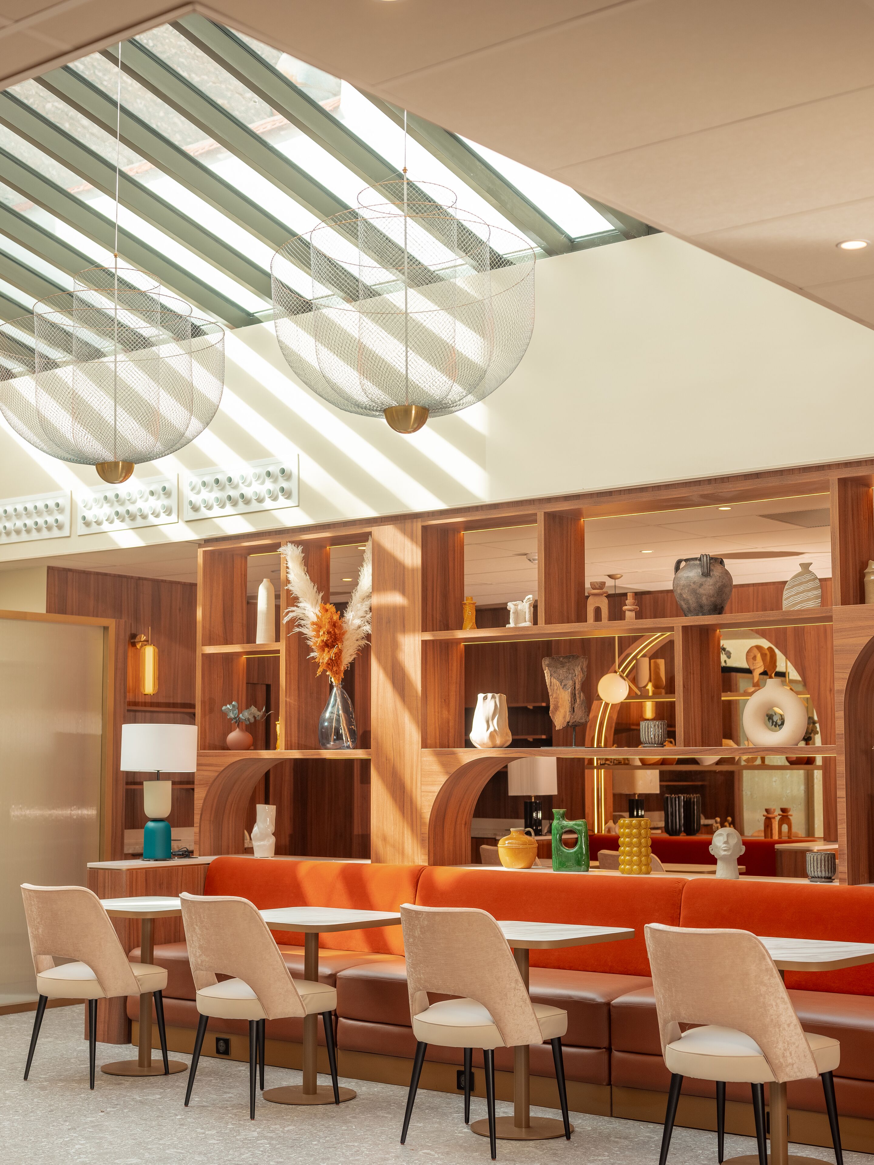 A modern interior with a wooden bar area, seating, and decorative lighting.